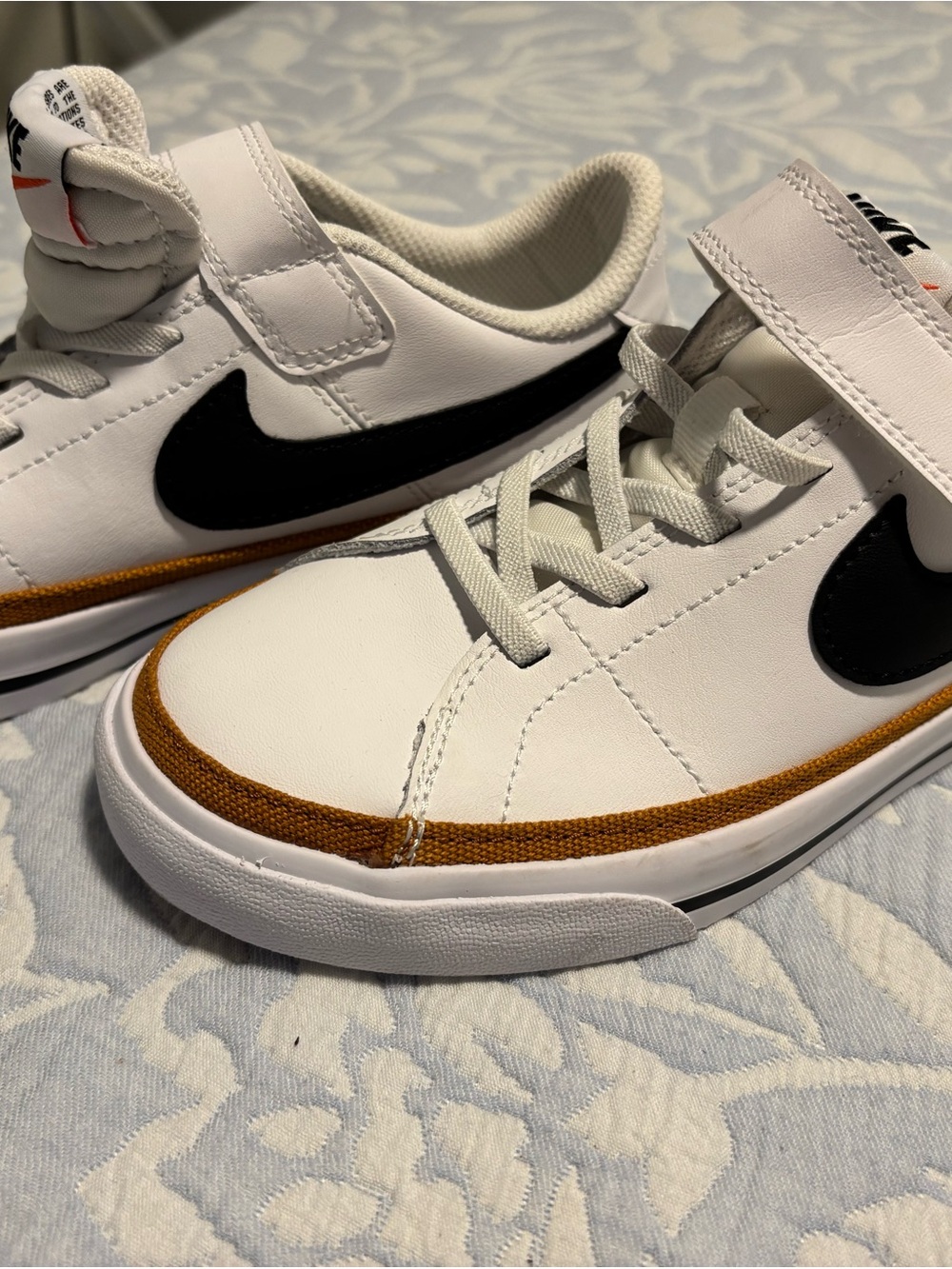 Nike Kids White Sneaker with Black Swoosh and Brown Trim